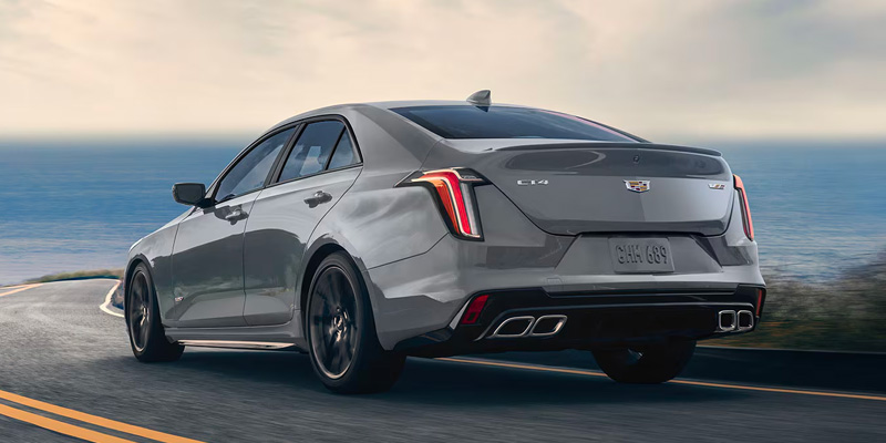 Rear drivers side view of a grey 2025 Cadillac CT4-V driving down the highway on a foggy day