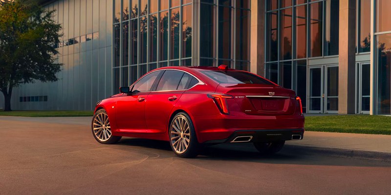 Rear drivers side view of a red 2025 Cadillac CT5 at dusk