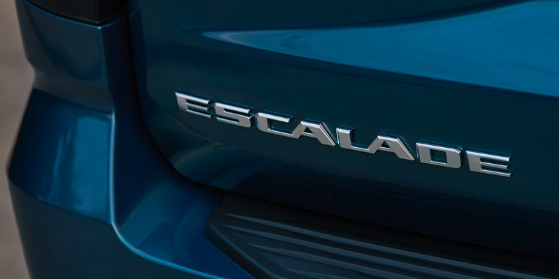 Cadillac Escalade rear badge with chrome lettering on a blue vehicle