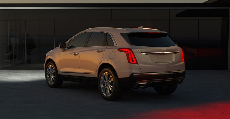 2026 Cadillac XT5 SUV rear three-quarter view in warm sunset lighting.
