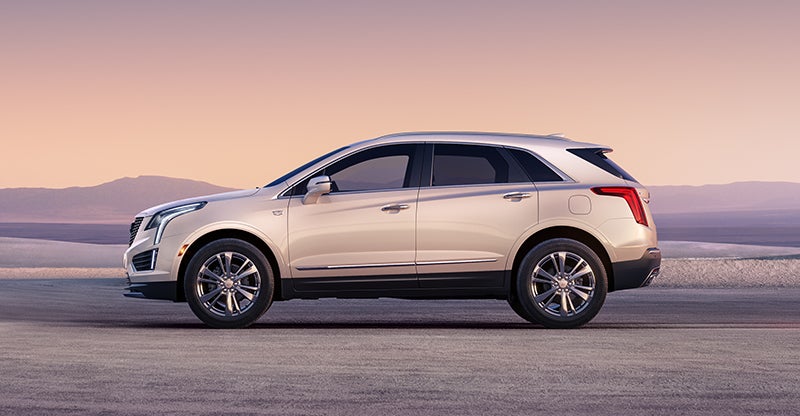 2026 Cadillac XT5 SUV side profile parked at sunset on open road.
