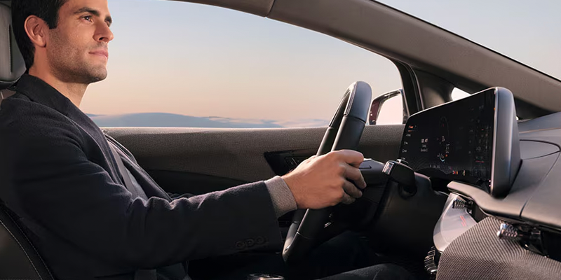 Driver inside a Cadillac Optiq electric SUV interior.