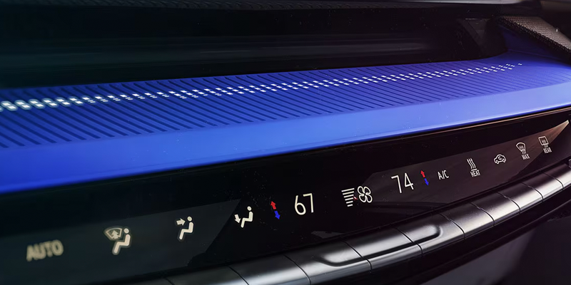 Cadillac Optiq interior climate controls and illuminated dashboard trim.