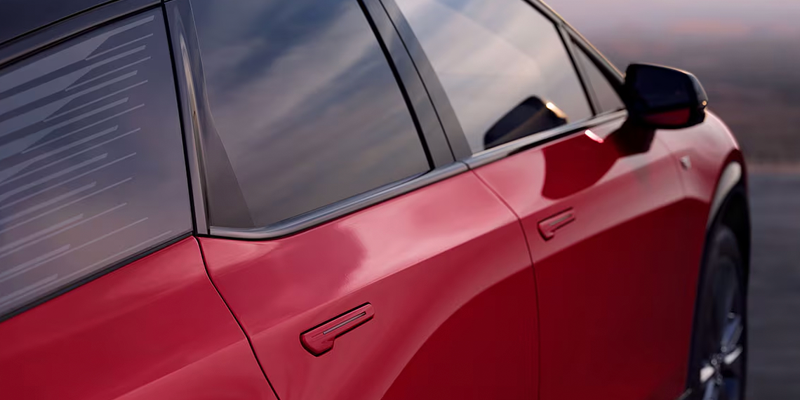 Close-up of red Cadillac Optiq exterior door and window detail.