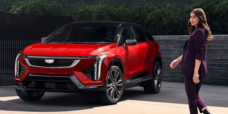 Red Cadillac Optiq electric SUV parked outdoors.