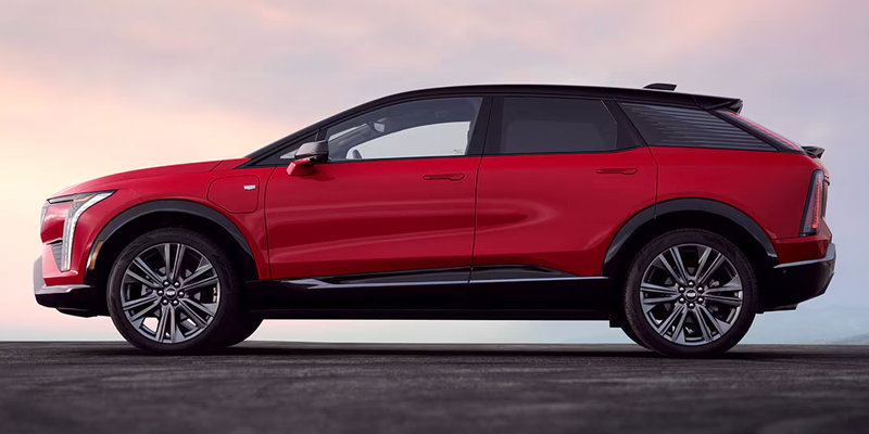 Side view of a red Cadillac Optiq electric SUV.